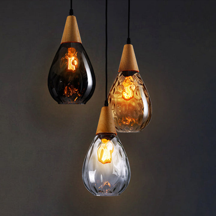 Elegant teardrop glass pendant fixture, modern hanging light enhancing kitchen aesthetics.