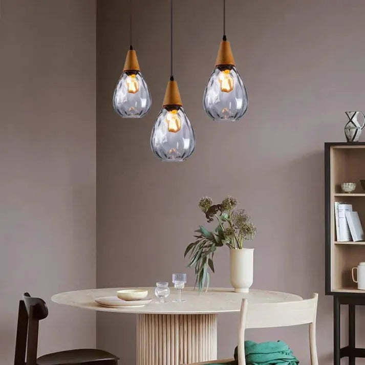 Sleek teardrop glass pendant light, ambient hanging fixture for kitchen or dining.