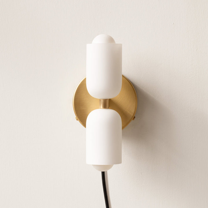 Minimalist modern wall lamp providing soft uplight downlight ambient bedroom lighting.