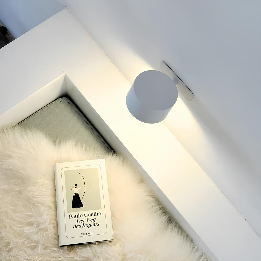 Modern wireless wall light, rechargeable LED lamp with adjustable head for accent lighting.