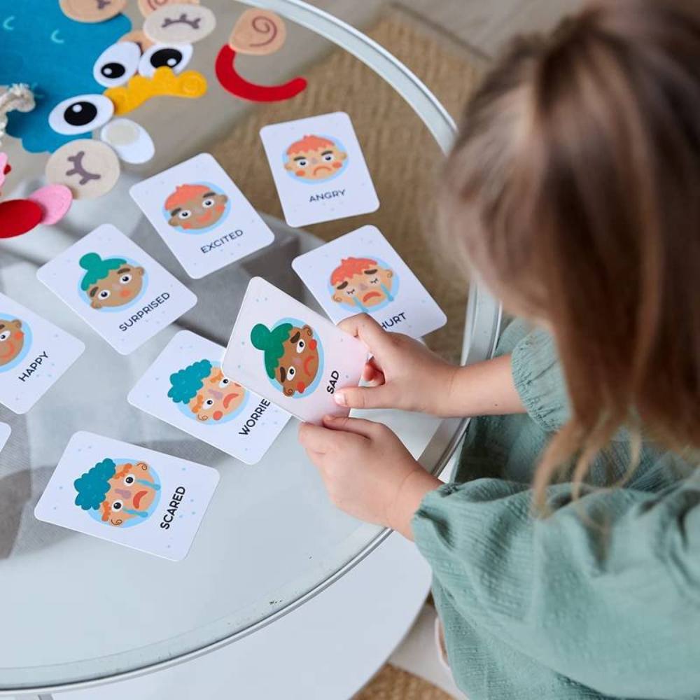Toddler plays with a Montessori facial expression toy, learning about emotions and early speech development.