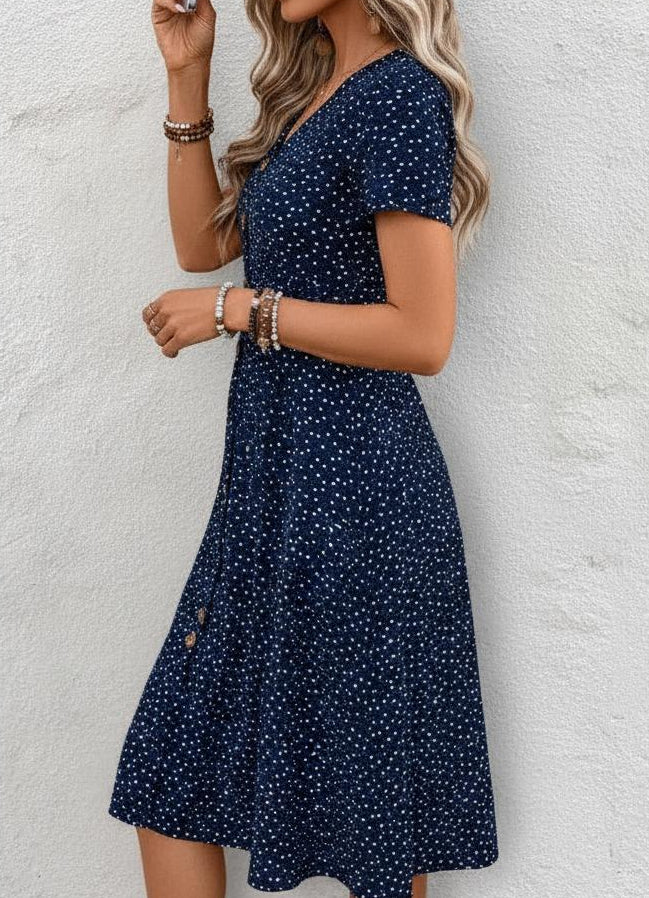 Women's navy blue polka dot A-line midi dress with button front detail.