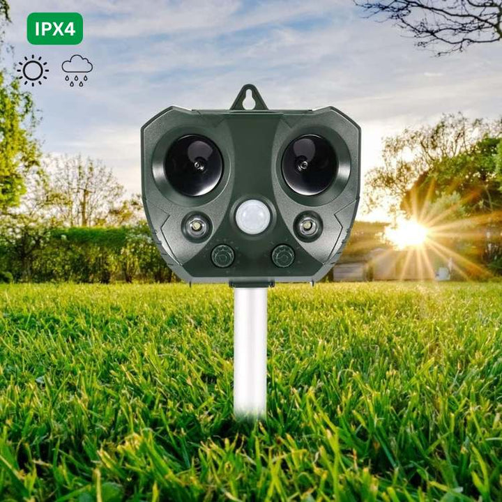 Close-up of a solar-powered ultrasonic bird deterrent device installed in a garden. Ideal for outdoor pest management.