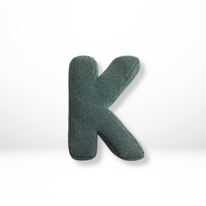 Soft velvet initial decorative cushion, enhancing personalized home interior style.