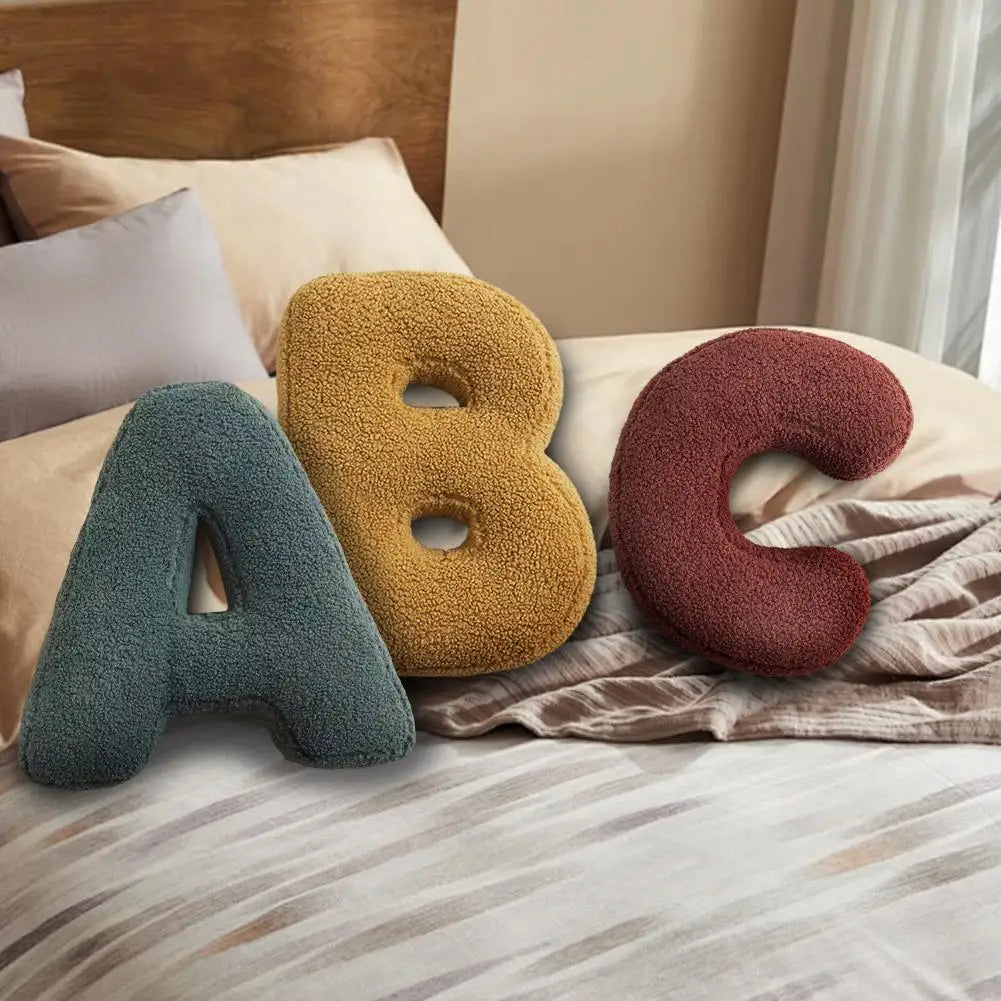 Luxurious velvet letter cushion, soft furnishings for personalized bedroom or lounge decor.