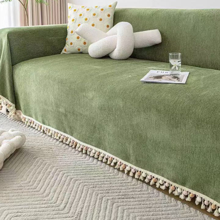 Boho pet friendly sofa cover protecting a couch, featuring herringbone pattern & stylish tassel fringe. Home decor.