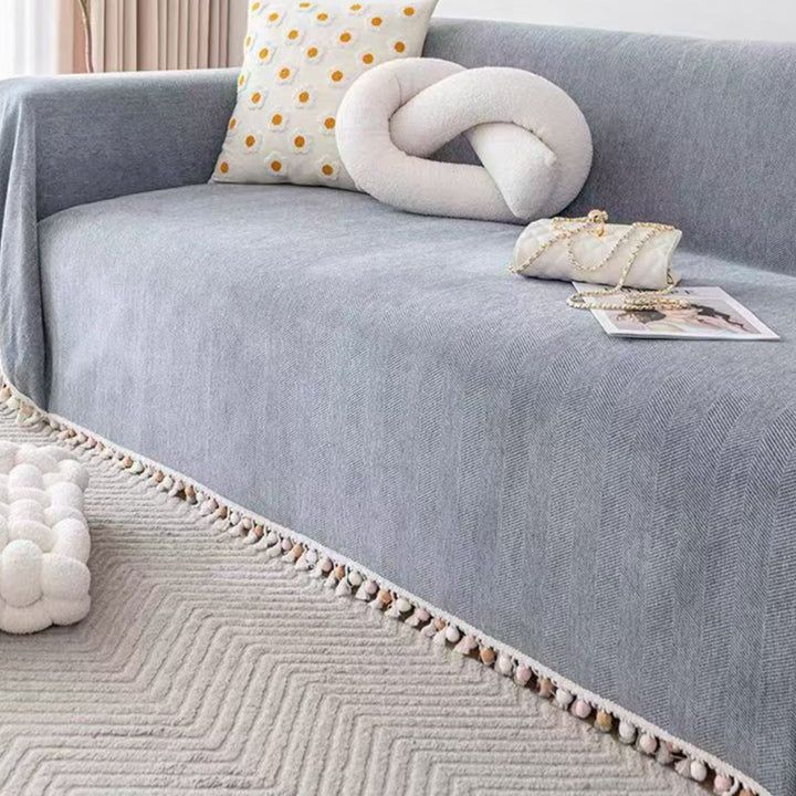 Chic boho sofa cover with herringbone pattern & decorative tassel fringe, perfect for pet friendly living room decor.