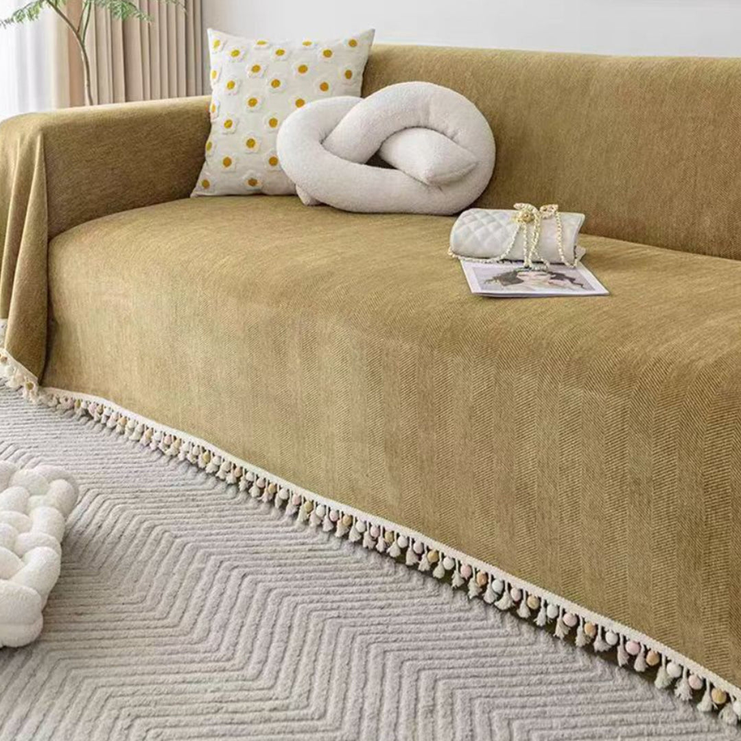 Durable pet friendly furniture protector: a herringbone sofa cover with boho tassel fringe for stylish living rooms.