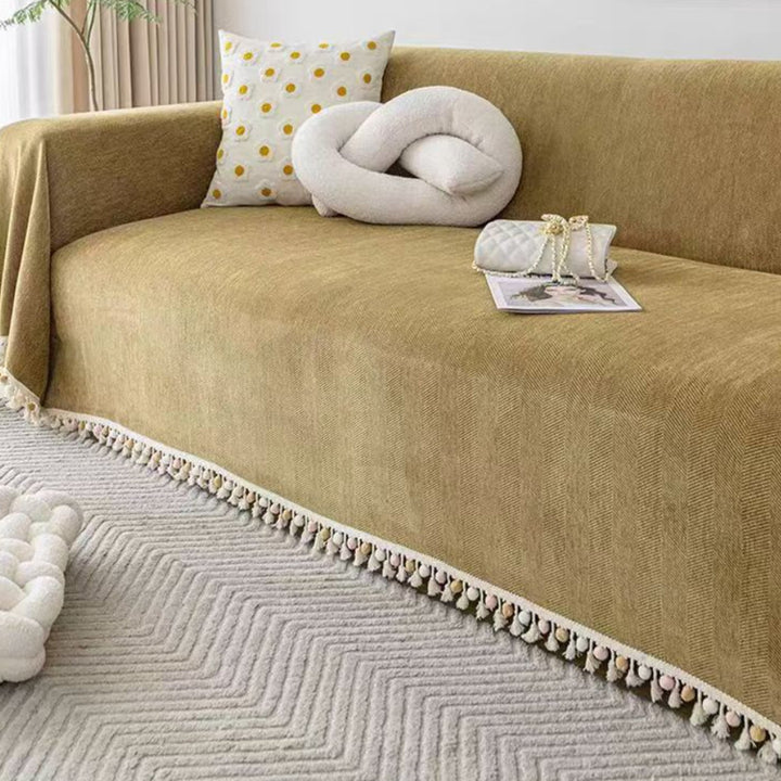 Durable pet friendly furniture protector: a herringbone sofa cover with boho tassel fringe for stylish living rooms.
