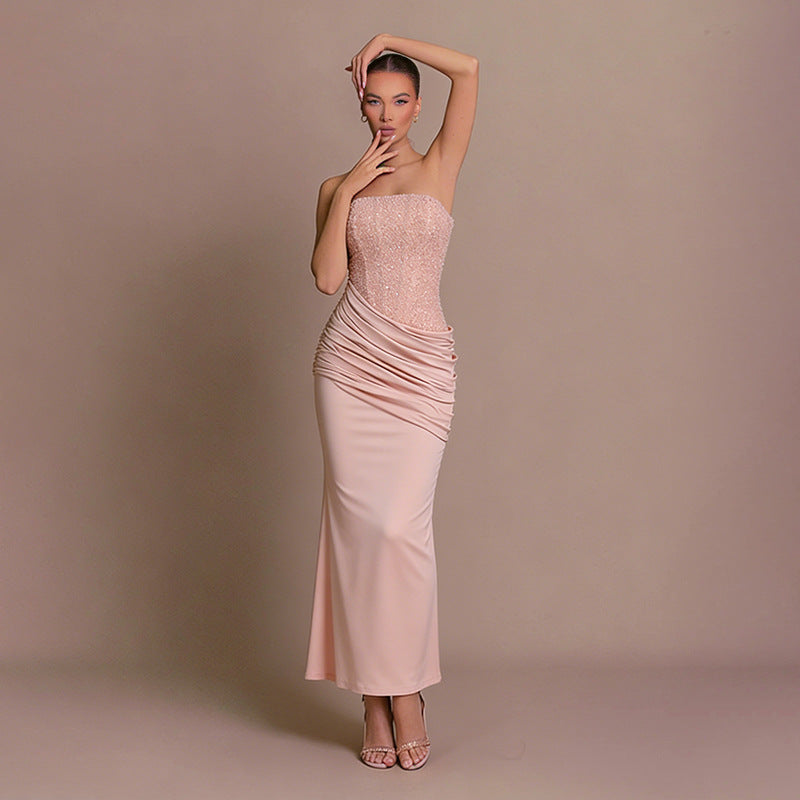 Women's elegant pink strapless bodycon maxi dress with ruched details, ideal for evening events.
