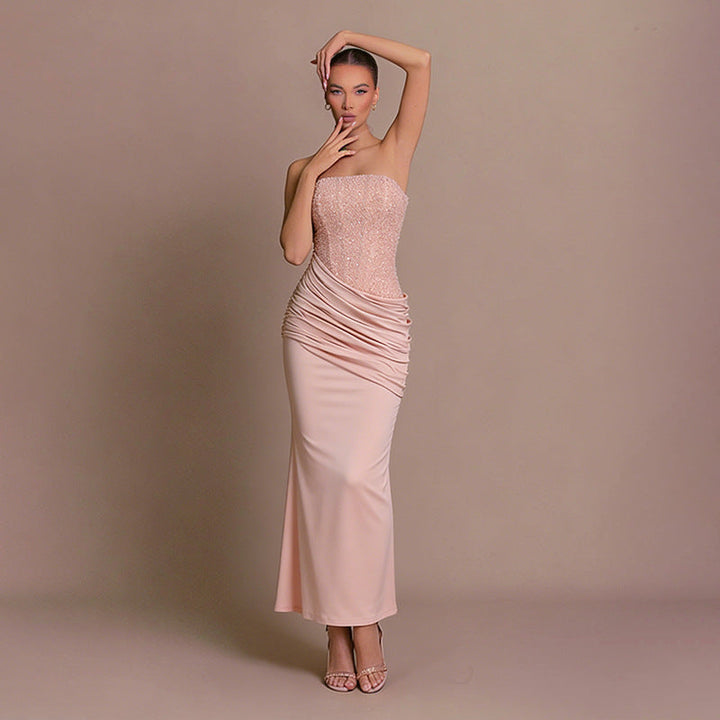 Women's elegant pink strapless bodycon maxi dress with ruched details, ideal for evening events.