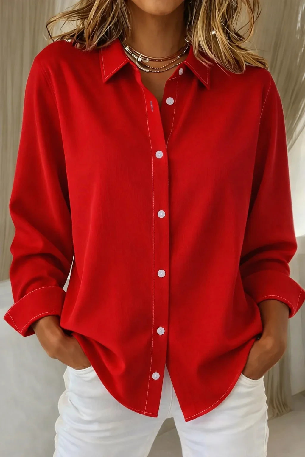 Versatile women's pink long-sleeve blouse with a classic collar, full button front, and distinctive contrast stitch detail.