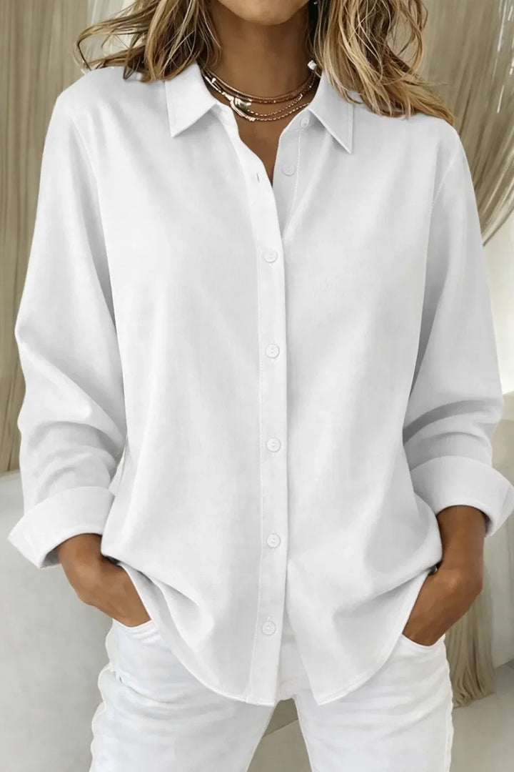 Close-up of chic pink women's blouse: collared, long-sleeve, button-front, highlighting elegant contrast stitching.