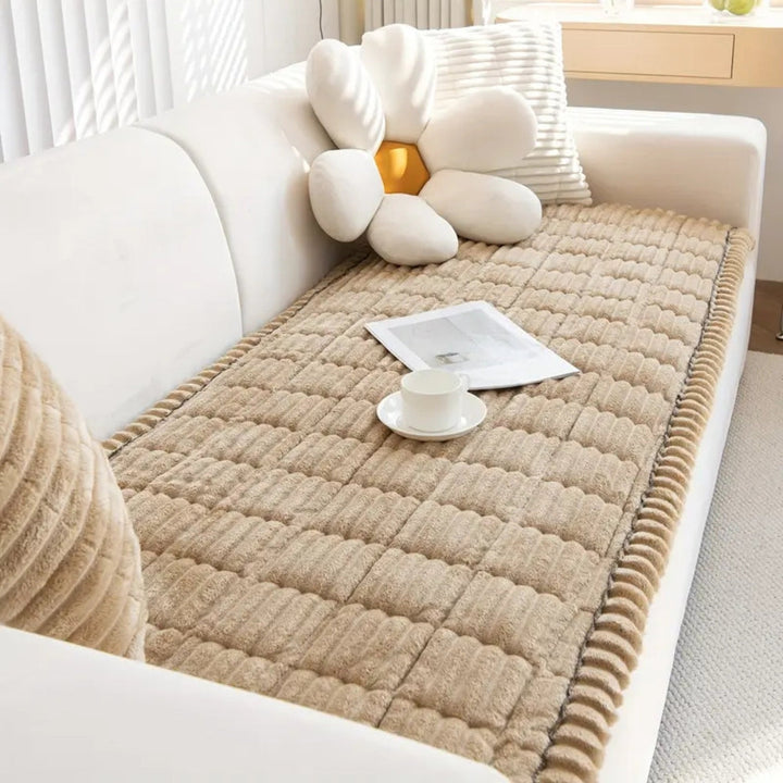 Cozy plush fleece sofa mat, quilted design enhances living room decor, soft texture comfort.