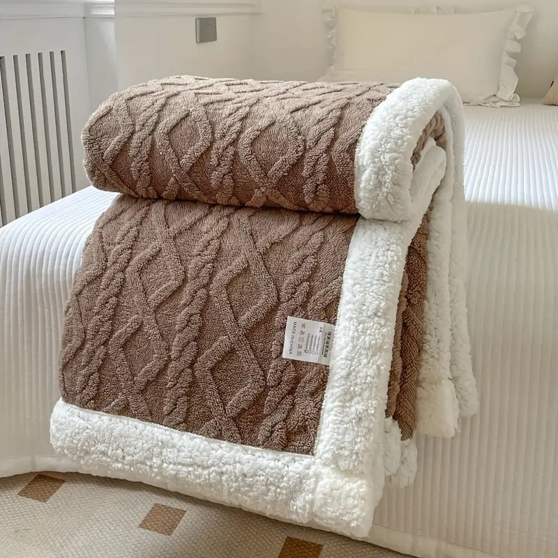 Neatly folded plush Sherpa throw blanket, displaying its soft texture and cozy appeal for home decor.