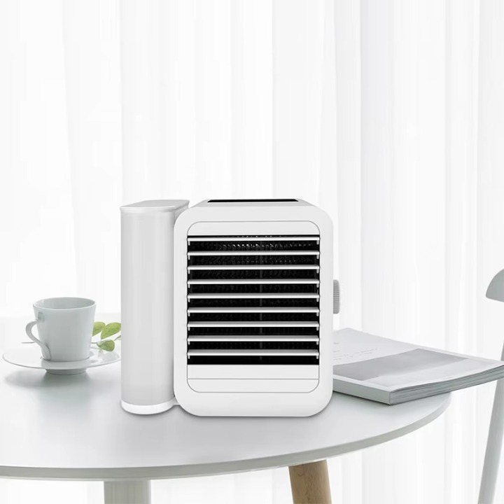 Unisex portable mini air cooler and humidifier on a desk, a compact USB fan for personal cooling.