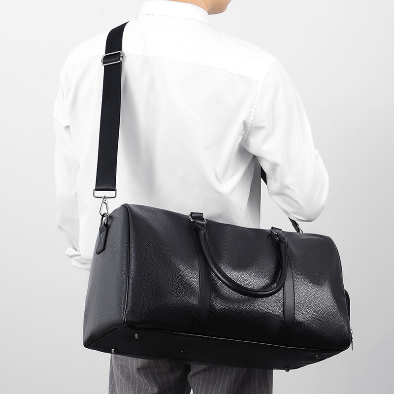 Men's black leather travel duffle bag with shoulder strap, ideal for weekend trips & carry-on.