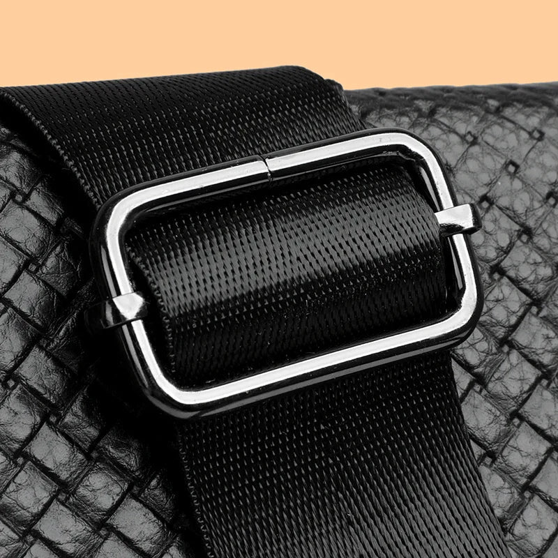 Close-up of rich genuine leather texture on men's compact shoulder bag. Premium quality.