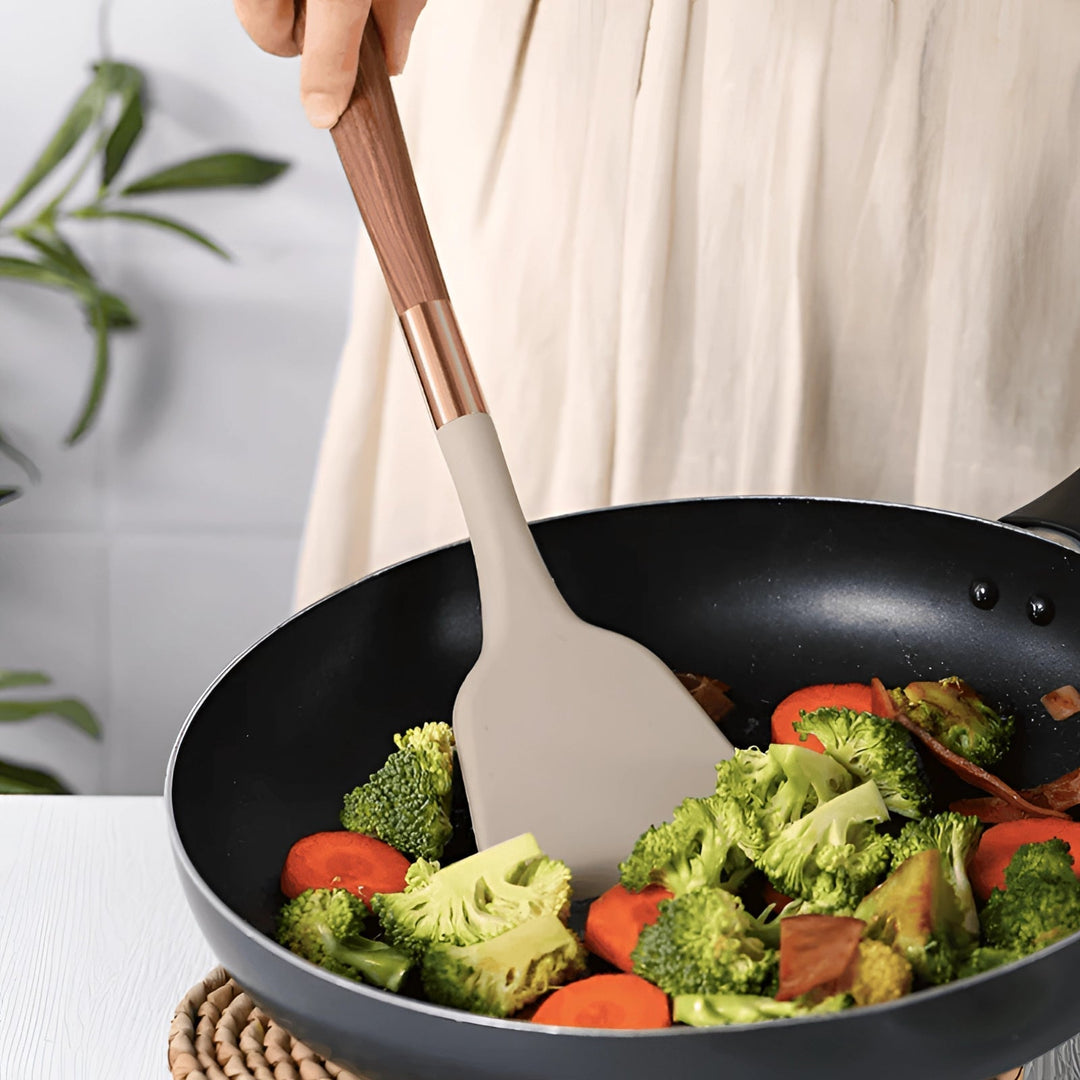 Home chef's premium cooking tools: non-stick silicone utensils with protective wood handles. Heat-resistant kitchen set.