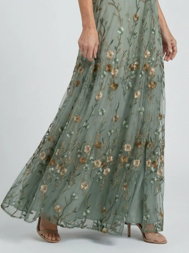Elegant women's sage green maxi dress featuring intricate floral embroidery, v-neck, and drop waist, perfect for occasions.