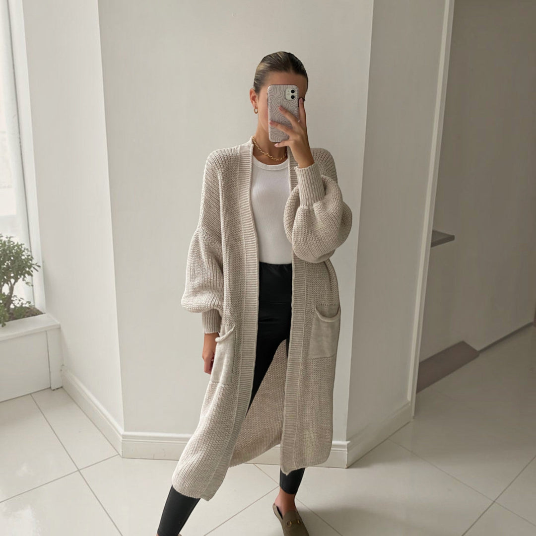 Soft knit longline women's cardigan in a sand color, offering an elegant drape for everyday wear.