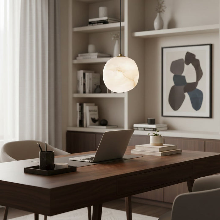 Minimalist pebble pendant light, brass finish, modern Japandi design, serene ambient lighting.