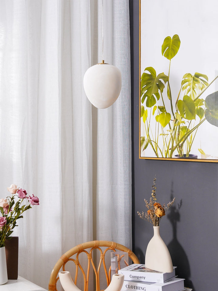 Japandi style pendant light, brass finish, pebble shape, enhances serene and calm interiors.