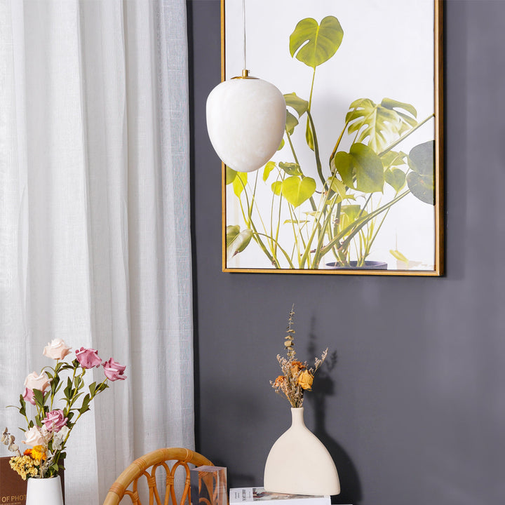 Decorative sculptural pendant light, brass finish, pebble design, for modern home ambiance.