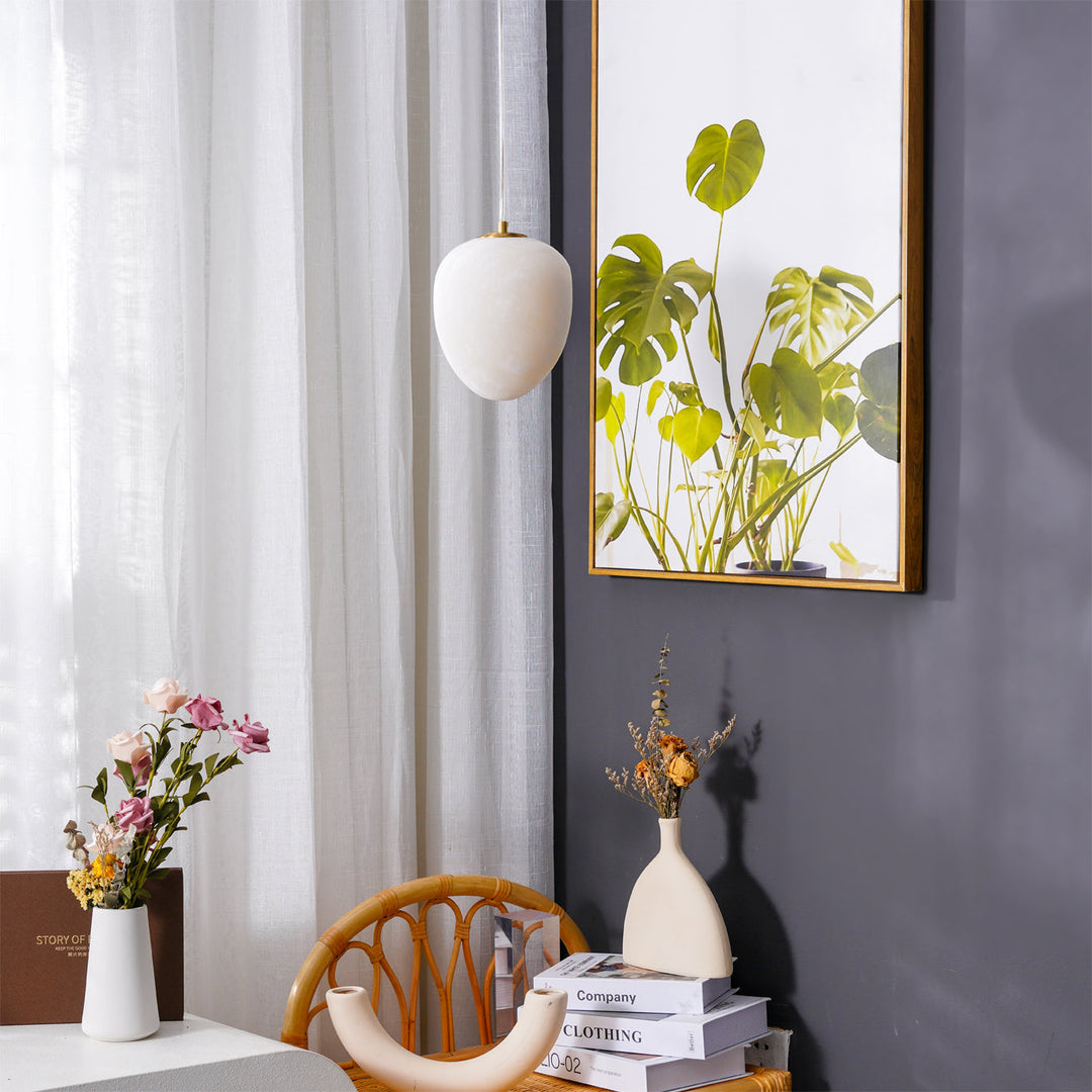 Elegant modern pendant lamp, brass finish, sculptural pebble design, for sophisticated spaces.
