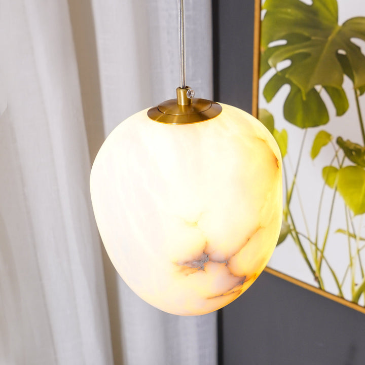 Serene sculptural pebble pendant light, brass finish, classic Japandi style for ambient glow.