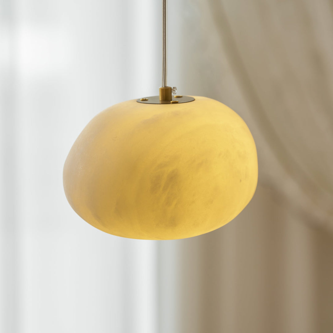 Elegant brass finish pendant light, pebble sculpture, bringing serenity to modern homes.