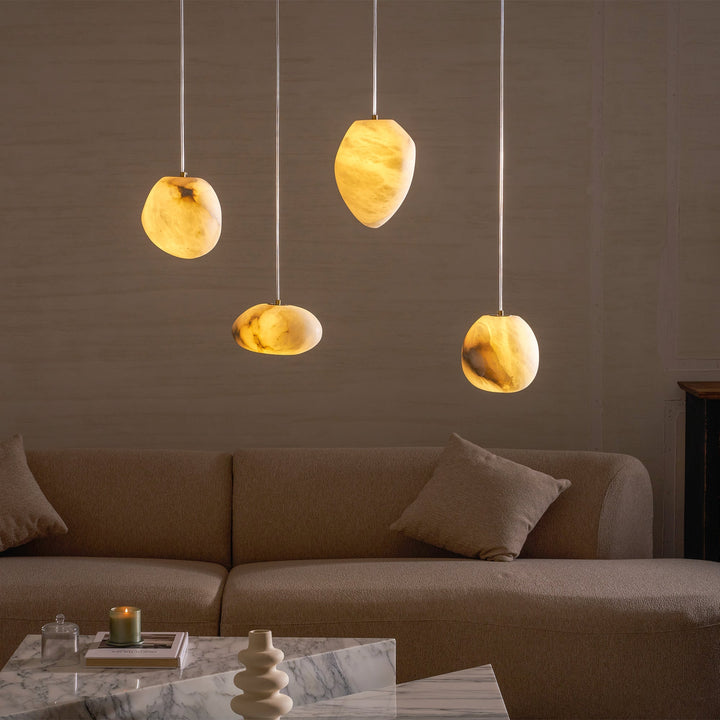Close-up of a decorative pebble pendant lamp, brass finish, providing serene ambient lighting.