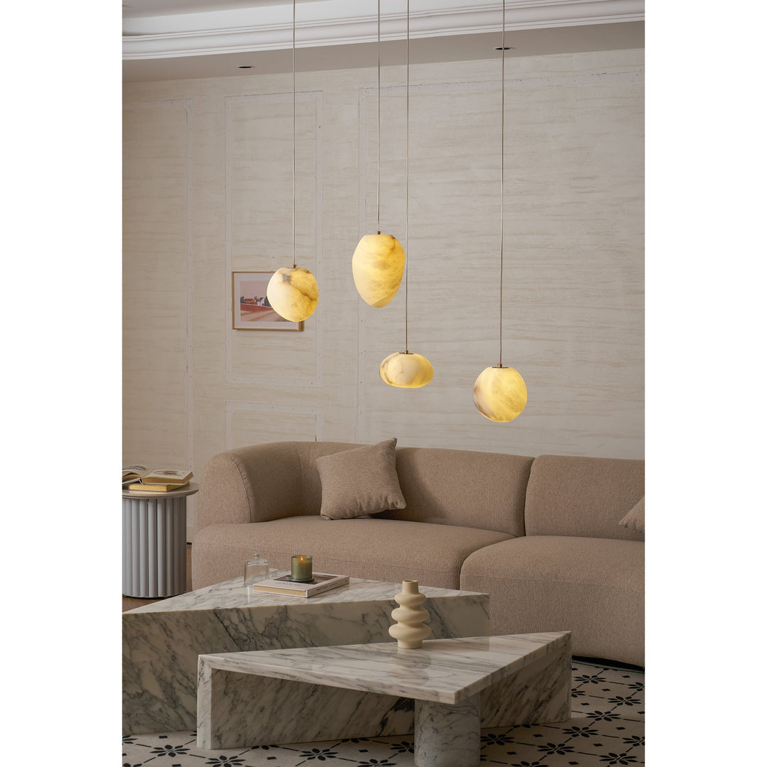 Modern sculptural pendant light, pebble design in brass, enhances any home decor.