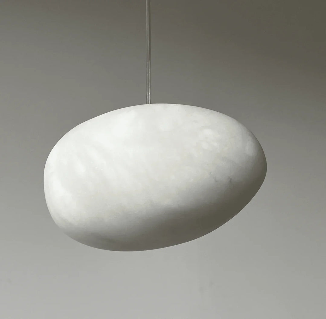 Japandi style sculptural pebble pendant light, brass finish, for serene and elegant homes.