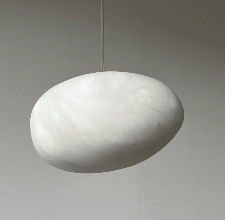 Japandi style sculptural pebble pendant light, brass finish, for serene and elegant homes.