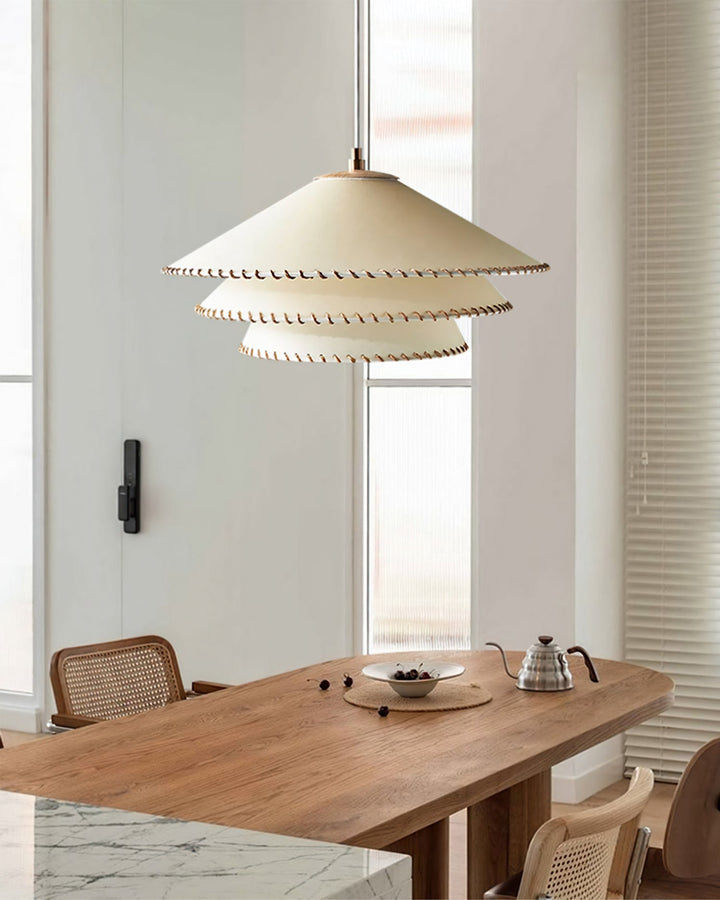 Warm neutral tiered pendant lamp, sculptural design, modern ambient glow for bedroom.