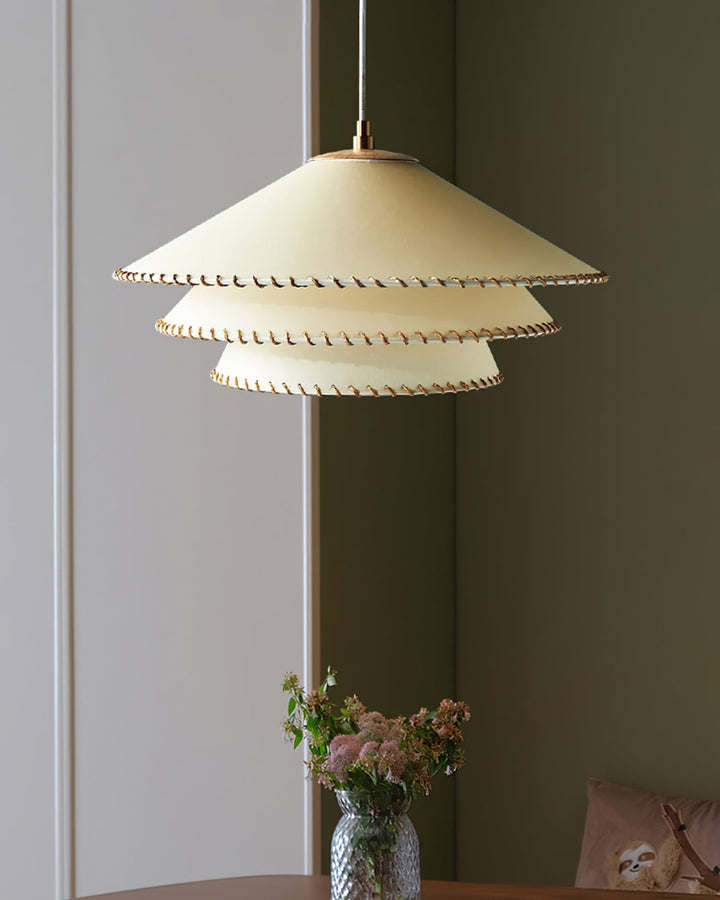 Entryway lighting: sculptural tiered pendant, warm neutrals, ambient glow.