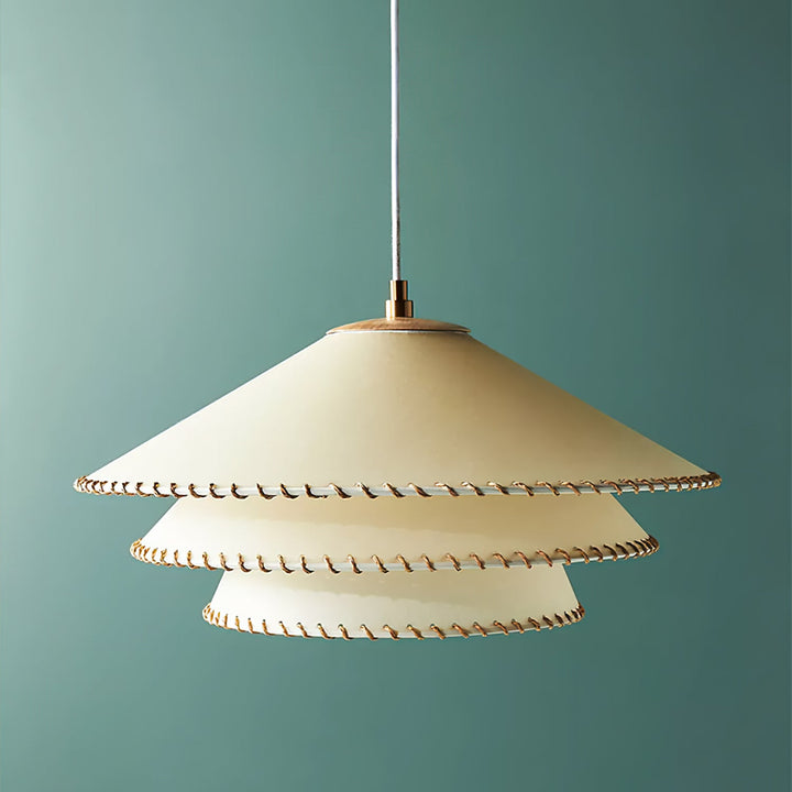Bohemian modern tiered pendant light, sculptural, warm neutrals, ambient glow.