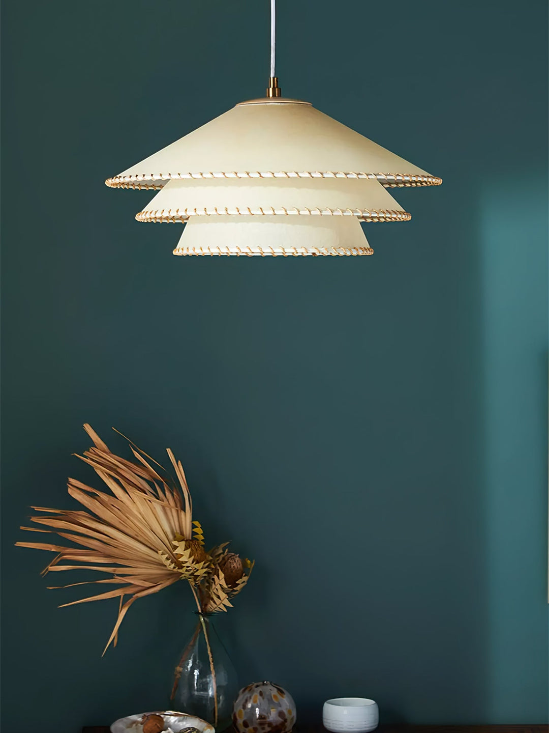 Bedroom decor: sculptural tiered pendant light, warm neutrals, soft ambient glow.
