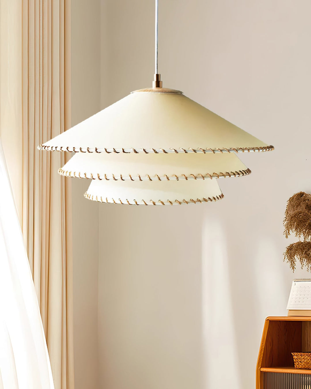 Bohemian tiered pendant light, warm neutrals, sculptural ceiling lamp for bedroom ambient glow.