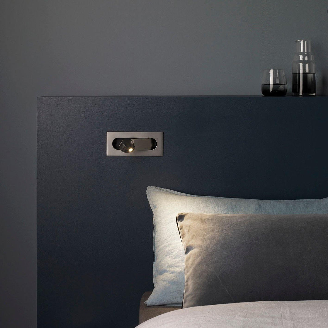 Adjustable LED reading light, sleek wall lamp, provides targeted task lighting for beds.