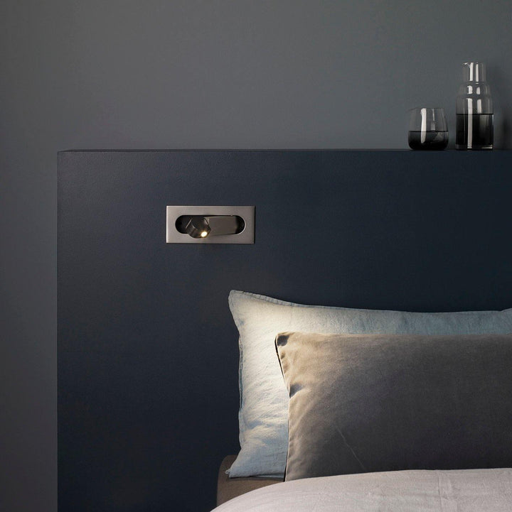 Adjustable LED reading light, sleek wall lamp, provides targeted task lighting for beds.