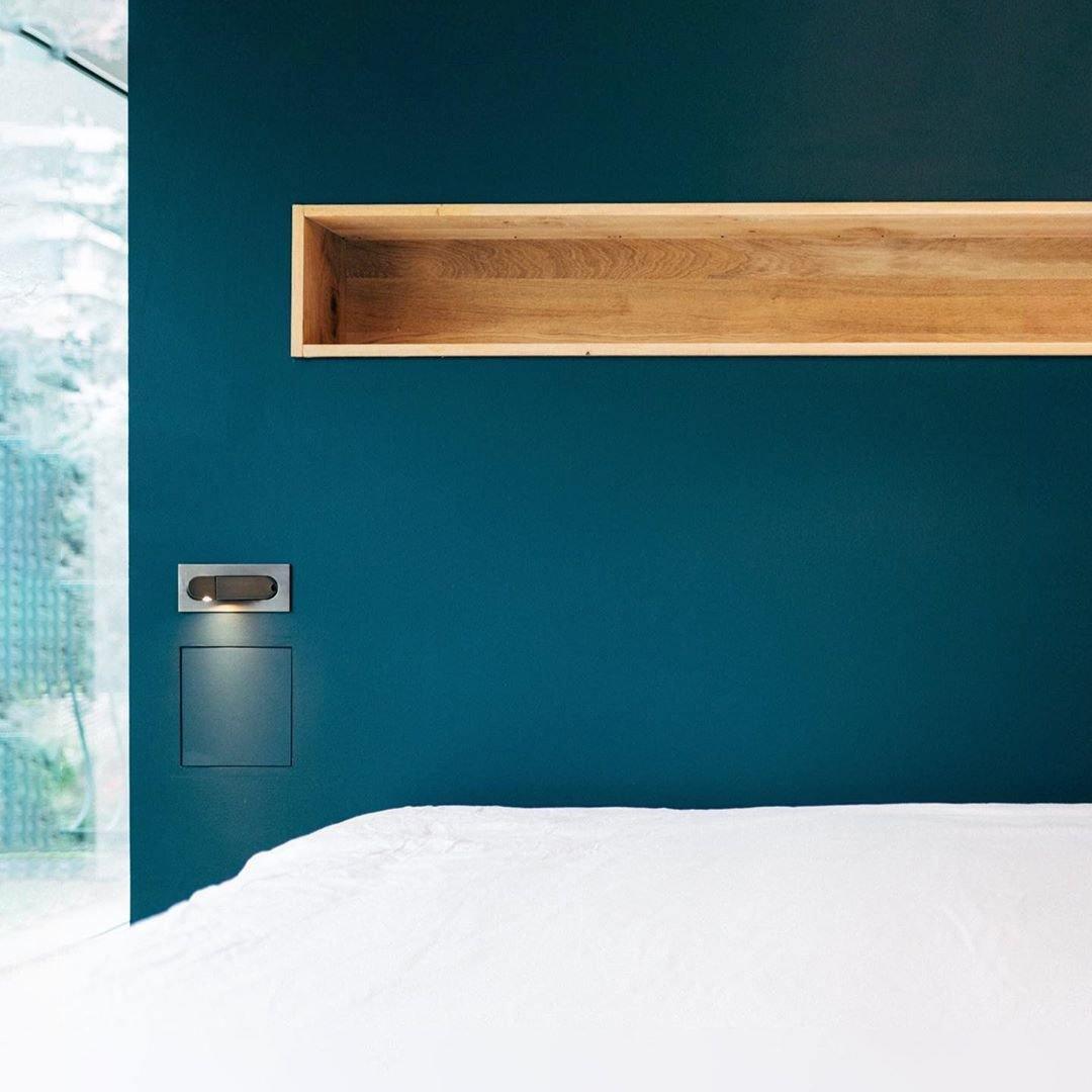 Modern wall-mounted LED reading lamp, adjustable and energy-efficient for bedrooms.