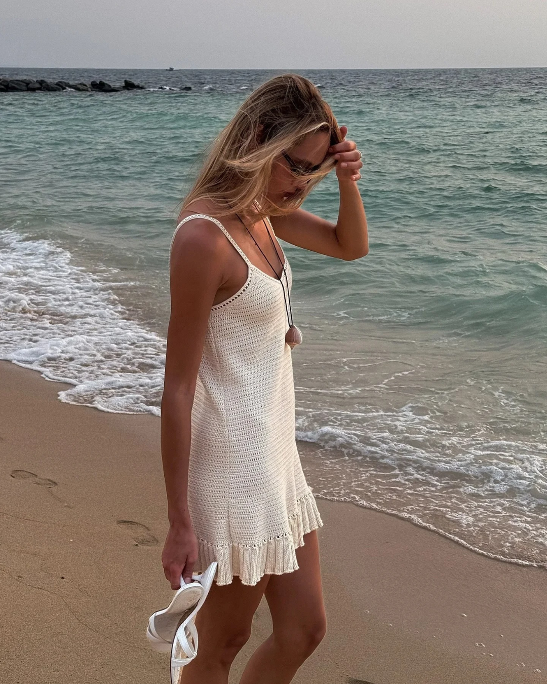 Bohemian frill hem mini dress for women, sleeveless V-neck. A stylish choice for summer fashion & resort outfits.