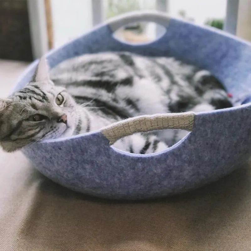 Handcrafted felt cat bed basket with durable handles, providing a warm and inviting space for cats.
