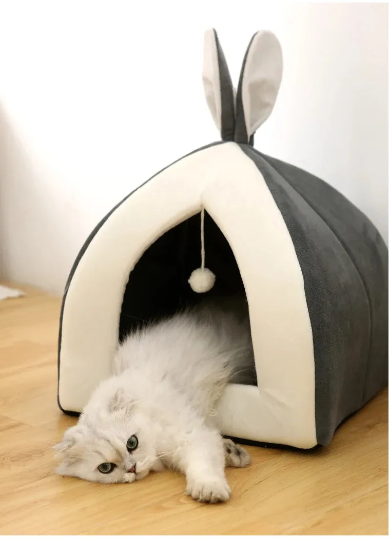 Comfortable rosa cave pet bed, soft and washable, designed for cats to cuddle and play with the attached ball.