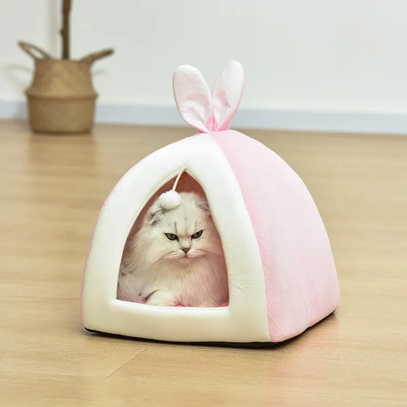 Luxurious cave cat bed in soft rosa, providing ultimate animal comfort and a stimulating play ball.