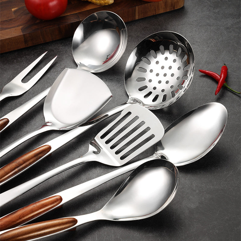 Close-up of a stainless steel kitchen utensil set, showing a spatula & ladle with smooth wooden handles. Essential cooking tools.