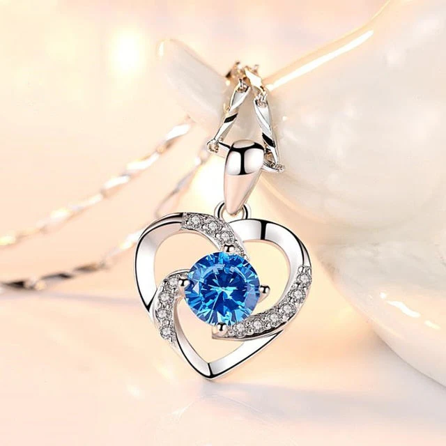 Close-up of a luminous sterling silver heart pendant necklace, ideal for gifting.