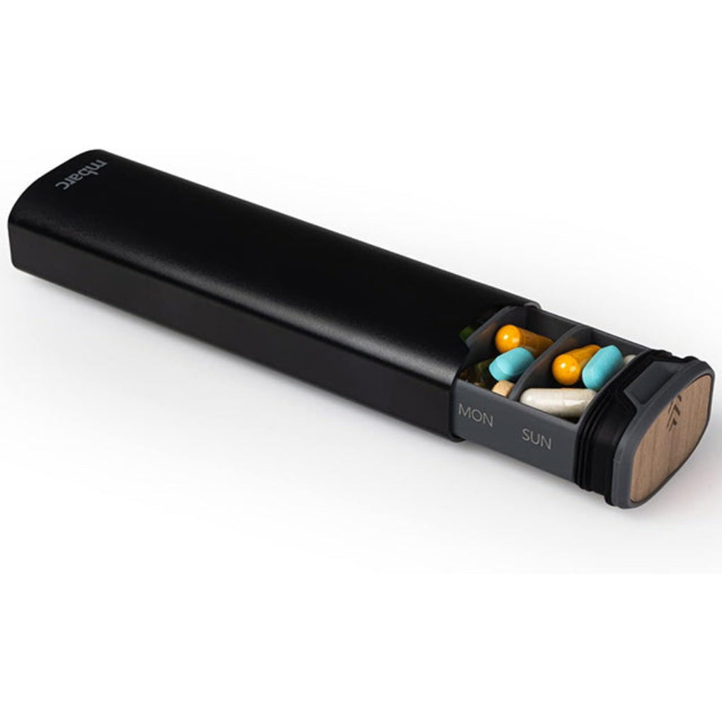 Compact travel pill case featuring a durable aluminum and wood design for 7-day organization.
